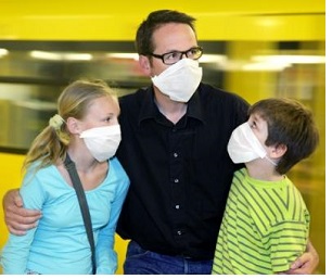 a family comprising a dad and his two children wearing face masks