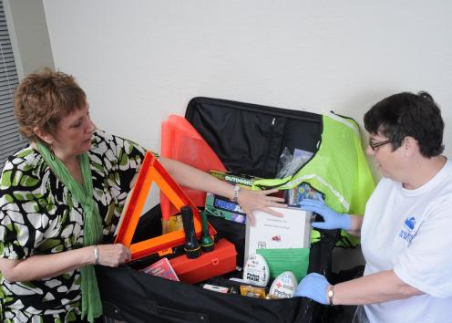 Two women discuss the contents of an emergency preparedness kit.
